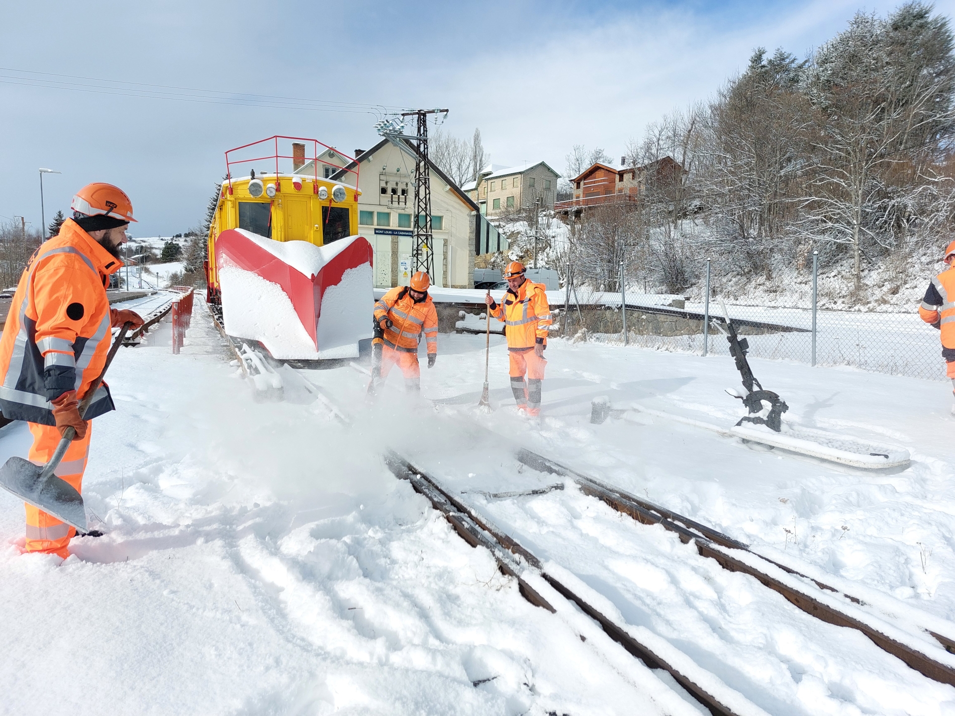 des agents et un engin chasse-neige dégagent les voies