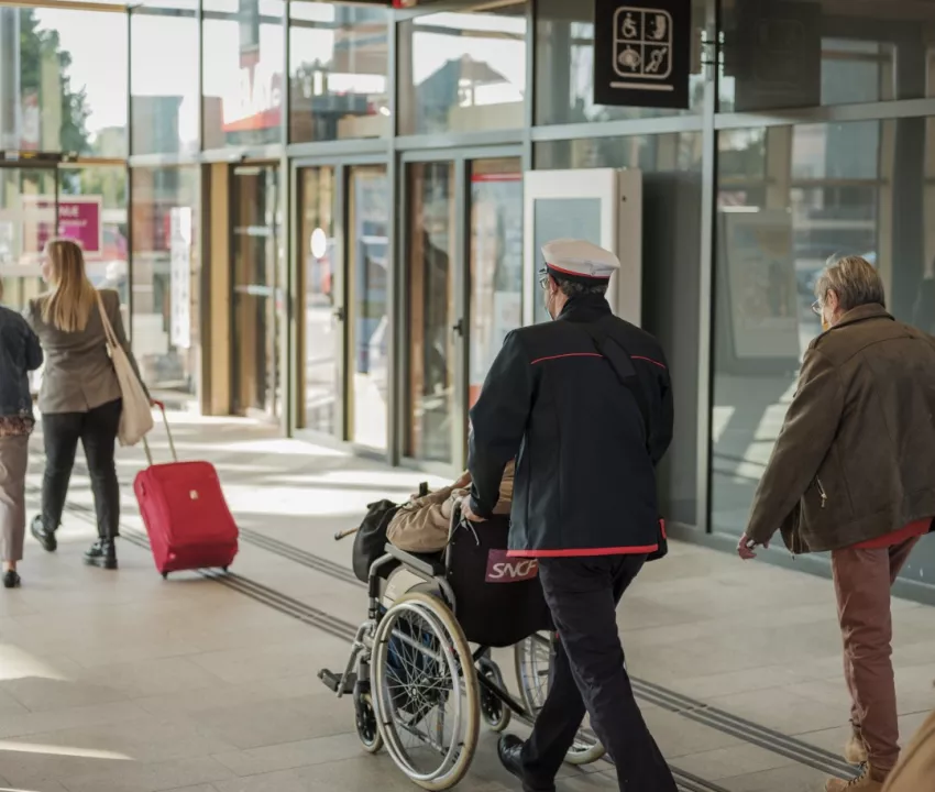 Agent SNCF accompagnant une personne en situation de handicap