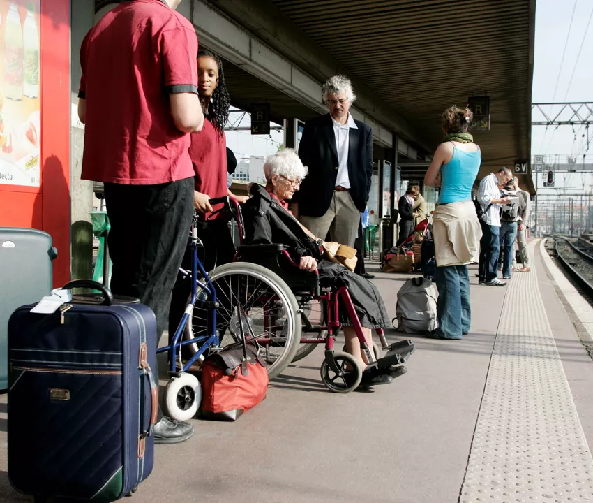 Personne âgée en fauteuil roulant avec agent SNCF